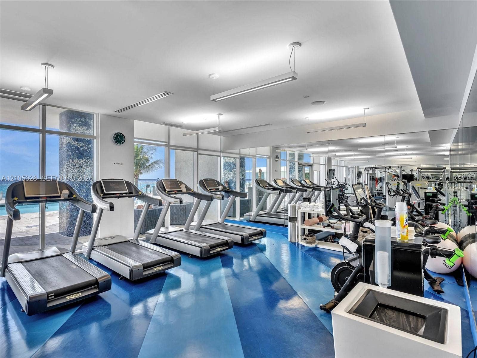 3951 S Ocean Drive, #1901, Hollywood, FL 33019 Expansive fitness center featuring a blue and dark blue patterned floor, floor-to-ceiling windows, and abundant natural light