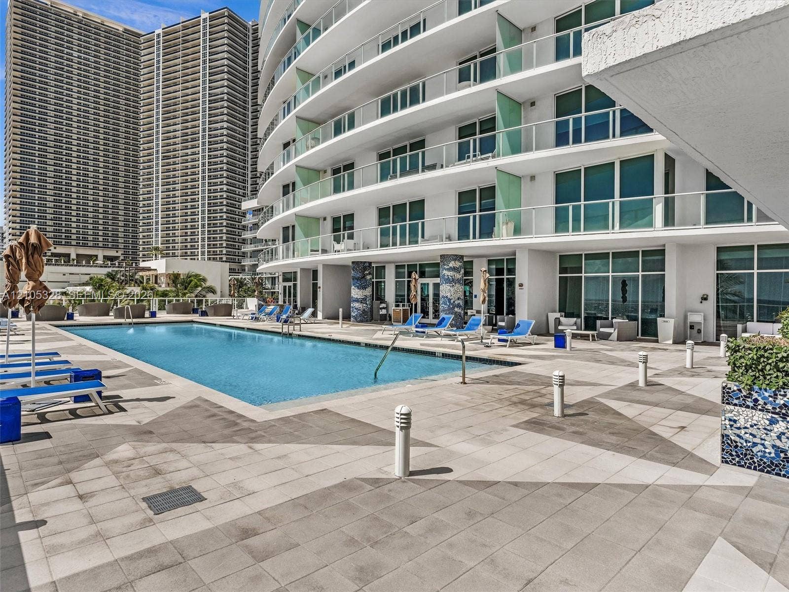 3951 S Ocean Drive, #1901, Hollywood, FL 33019 Experience oceanfront resort-style living at Apogee Beach, featuring an inviting swimming pool, expansive pool deck, sleek glass railings, and direct access to the beach and Atlantic Ocean.