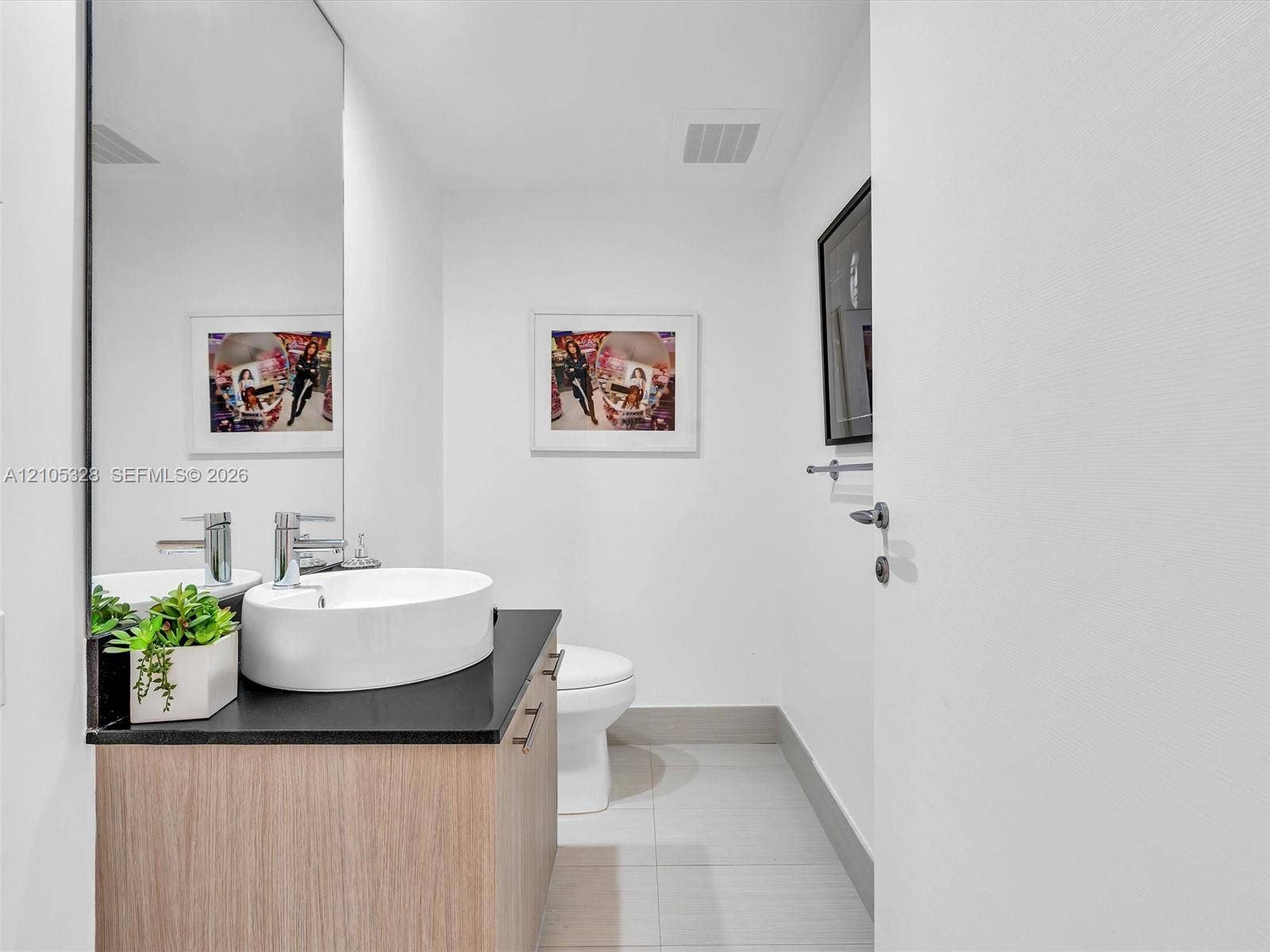 3951 S Ocean Drive, #1901, Hollywood, FL 33019 Floating wood-finish vanity with a dark countertop and vessel sink