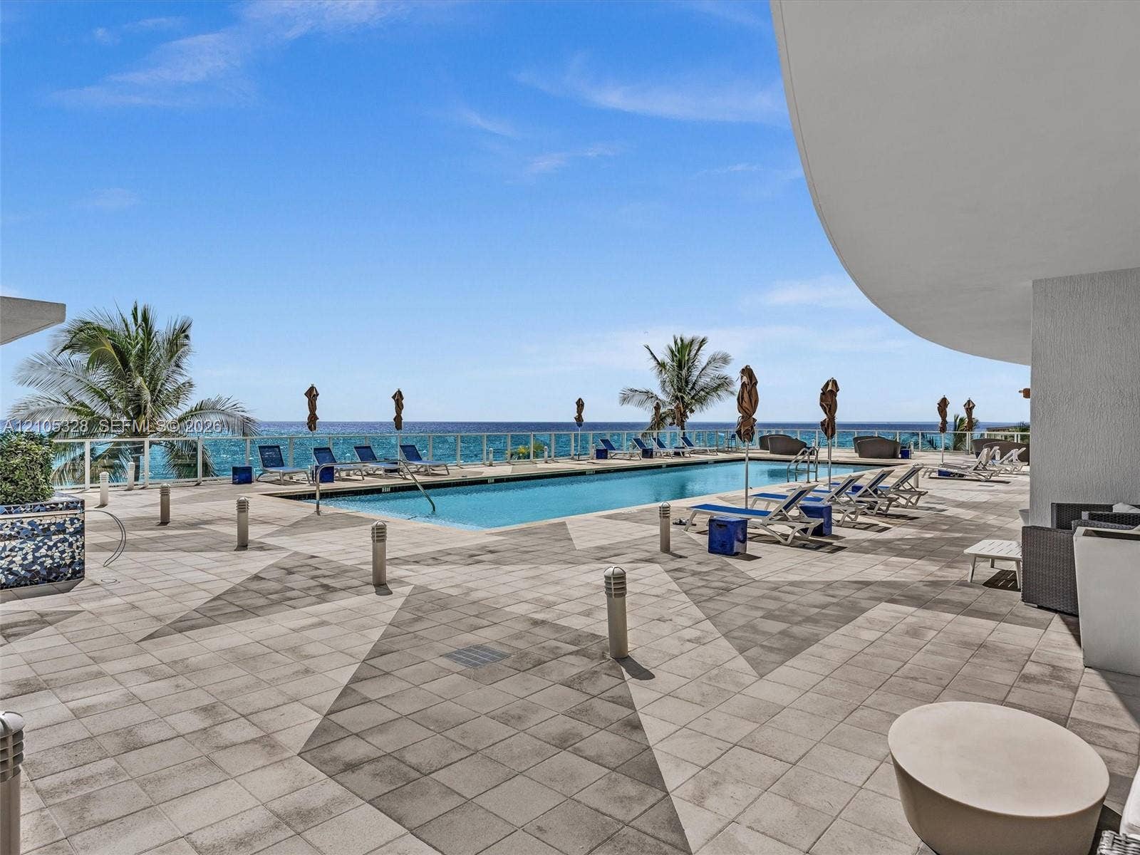 3951 S Ocean Drive, #1901, Hollywood, FL 33019 Experience oceanfront resort-style living at Apogee Beach, featuring an inviting swimming pool, expansive pool deck, sleek glass railings, and direct access to the beach and Atlantic Ocean.