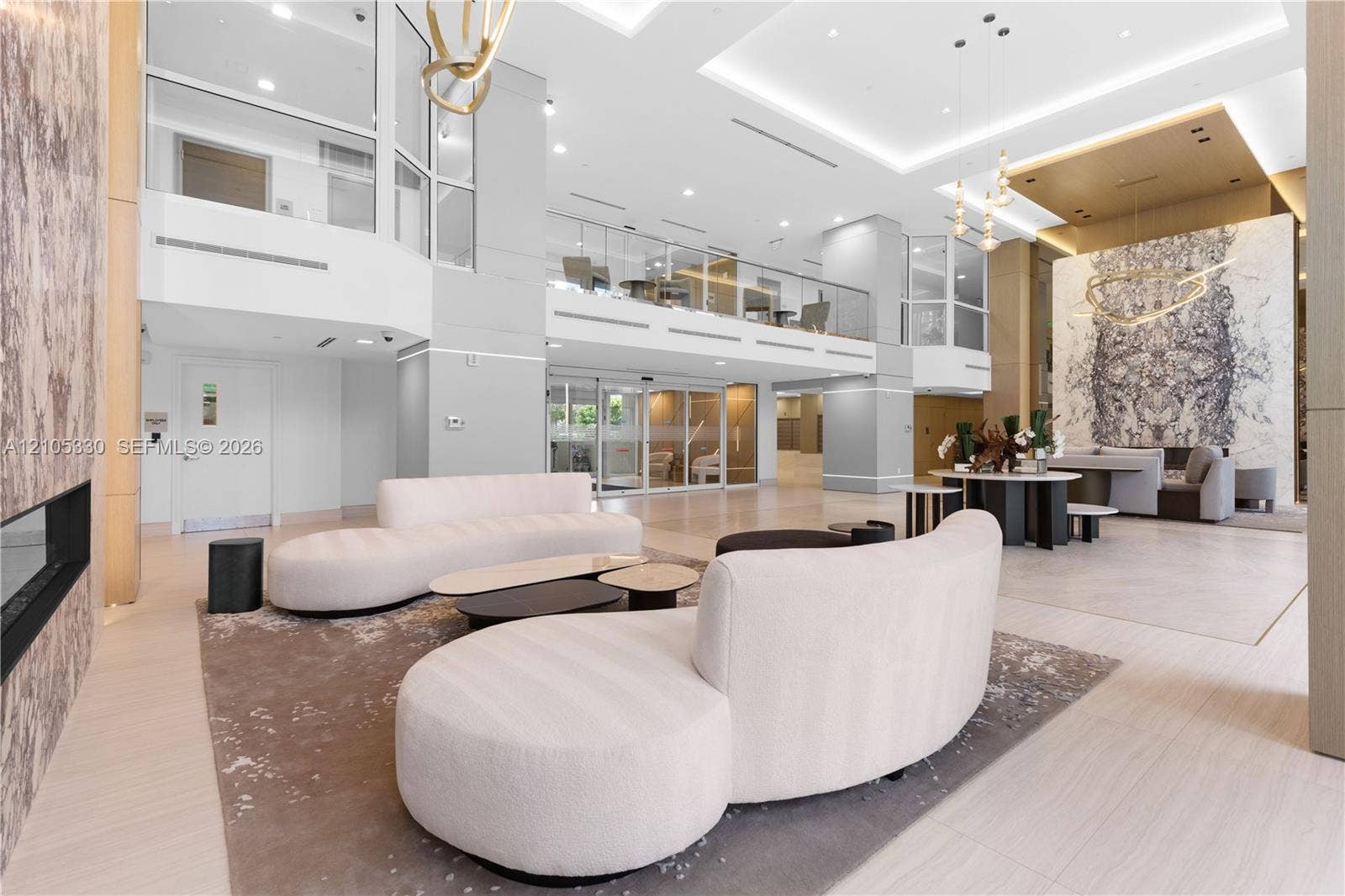 21205 Yacht Club Drive, #304, Aventura, FL 33180 Two-story lobby with high ceilings, recessed lighting, a built-in fireplace, and a glass-paneled mezzanine