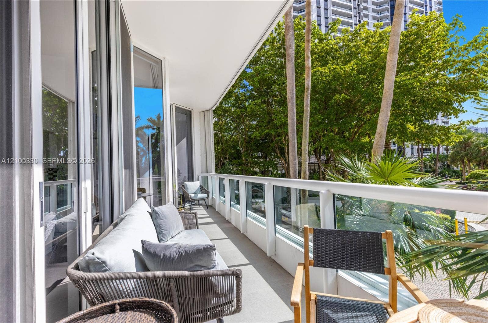 21205 Yacht Club Drive, #304, Aventura, FL 33180 Expansive balcony featuring a glass panel railing system, concrete flooring, and multiple sliding glass doors