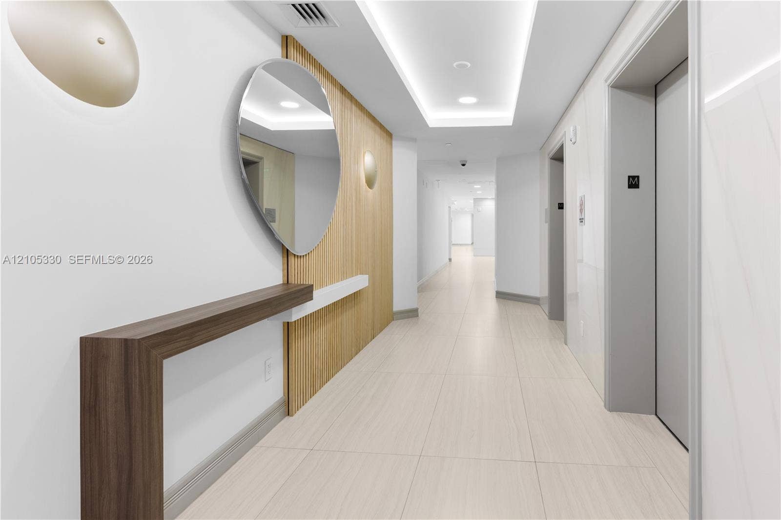 21205 Yacht Club Drive, #304, Aventura, FL 33180 Hallway with wood-finish paneling, contemporary wall sconces, wood-finish console table, and recessed ceiling lighting