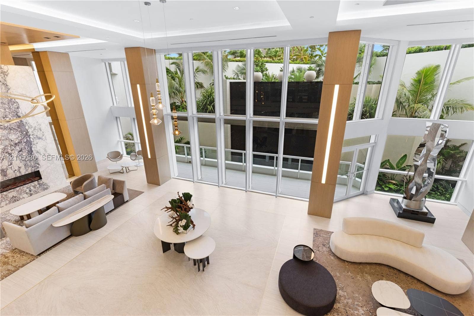 21205 Yacht Club Drive, #304, Aventura, FL 33180 Expansive interior with a high ceiling, floor-to-ceiling windows, recessed lighting, and a prominent fireplace featuring a stone surround