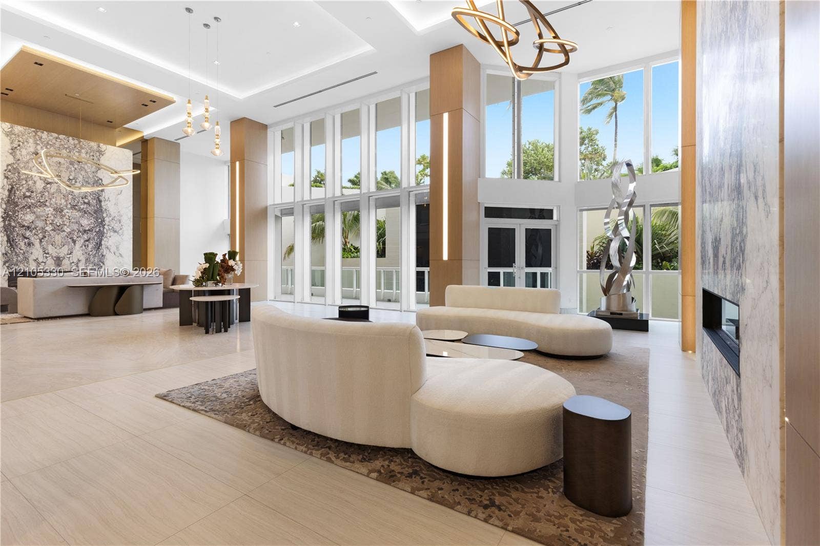 21205 Yacht Club Drive, #304, Aventura, FL 33180 Expansive double-height windows, a large format stone accent wall, recessed lighting, and a linear electric fireplace