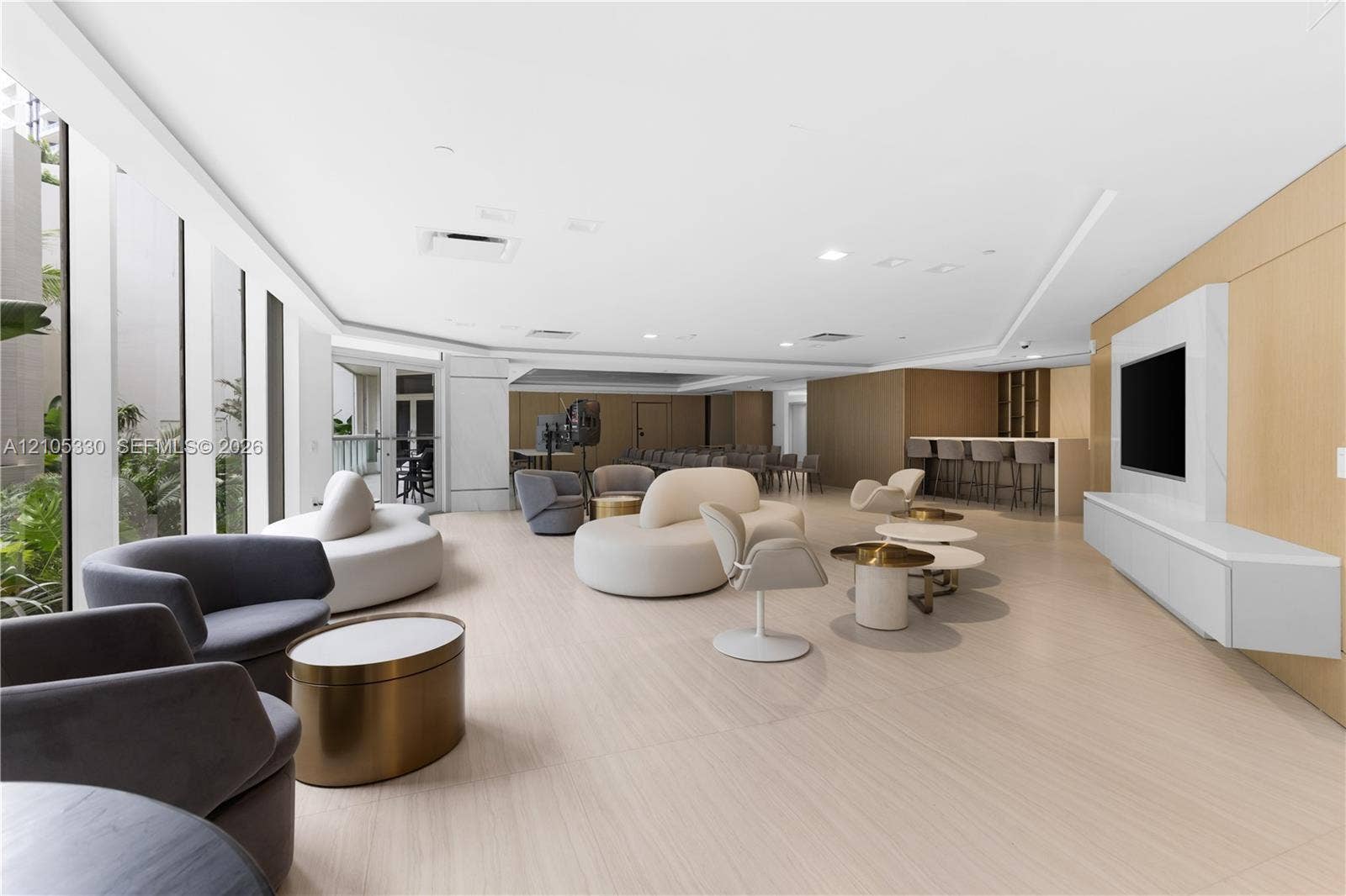 21205 Yacht Club Drive, #304, Aventura, FL 33180 Spacious communal area featuring light wood-finish flooring, a built-in media console with a mounted screen, a built-in bar area with seating, and floor-to-ceiling windows