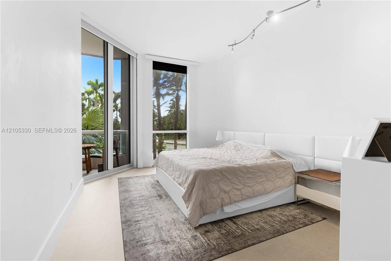 21205 Yacht Club Drive, #304, Aventura, FL 33180 Expansive floor-to-ceiling windows, track lighting, light-toned flooring, and a sliding glass door leading to a balcony