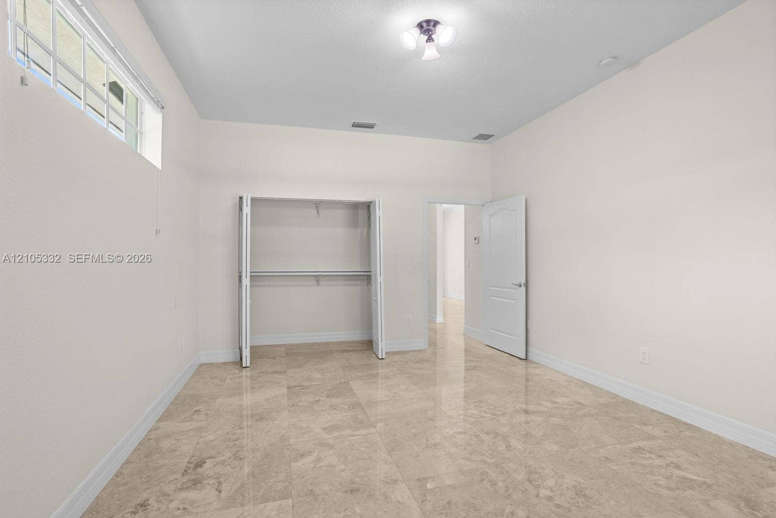 Recessed window, built-in closet with bi-fold doors, wood-finish flooring, and a flush mount ceiling light fixture