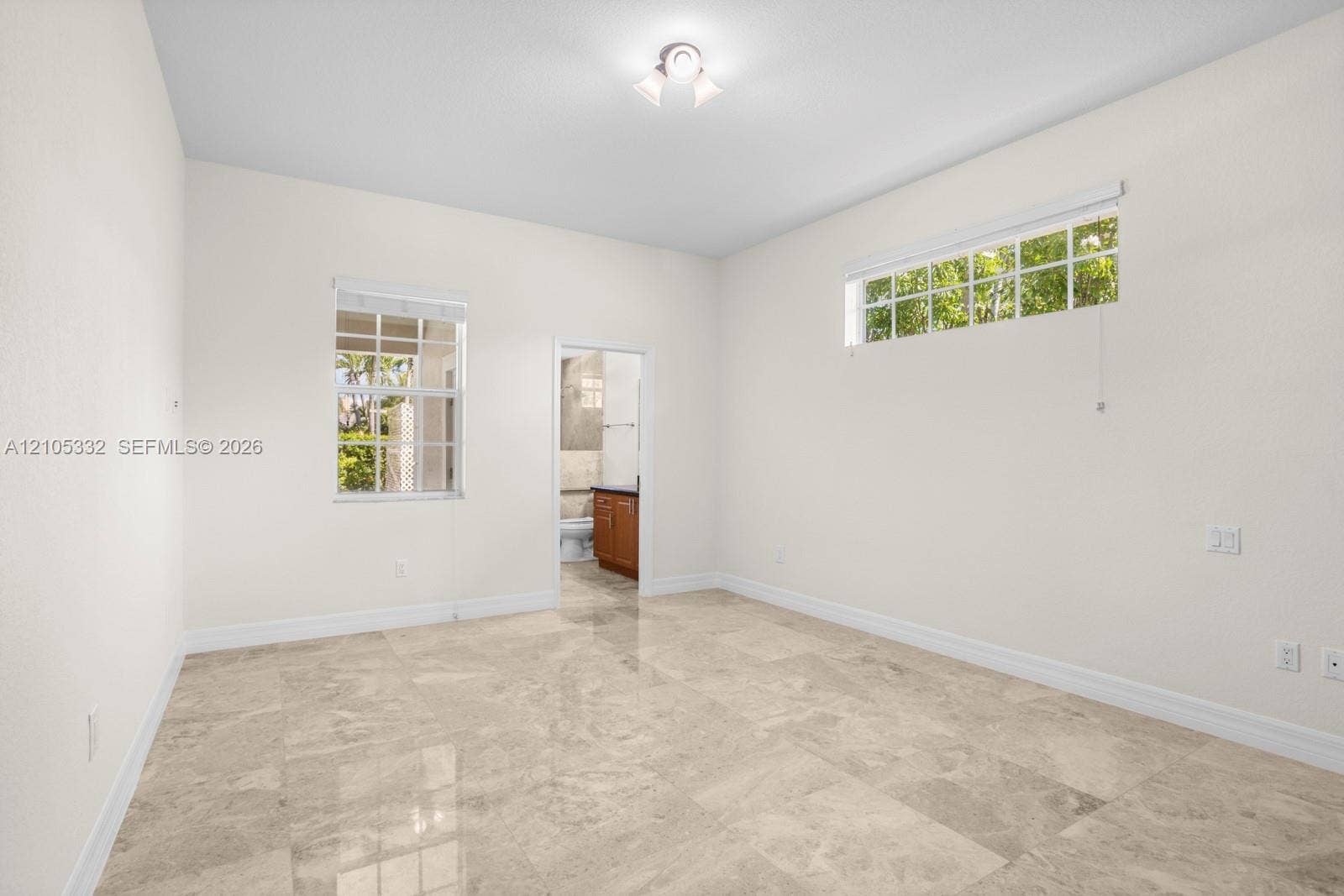 Light-toned tile flooring, white walls, two windows with blinds, recessed lighting fixture