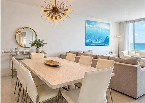 Spacious dining area with a modern sputnik chandelier, light wood-finish dining table, and tile flooring