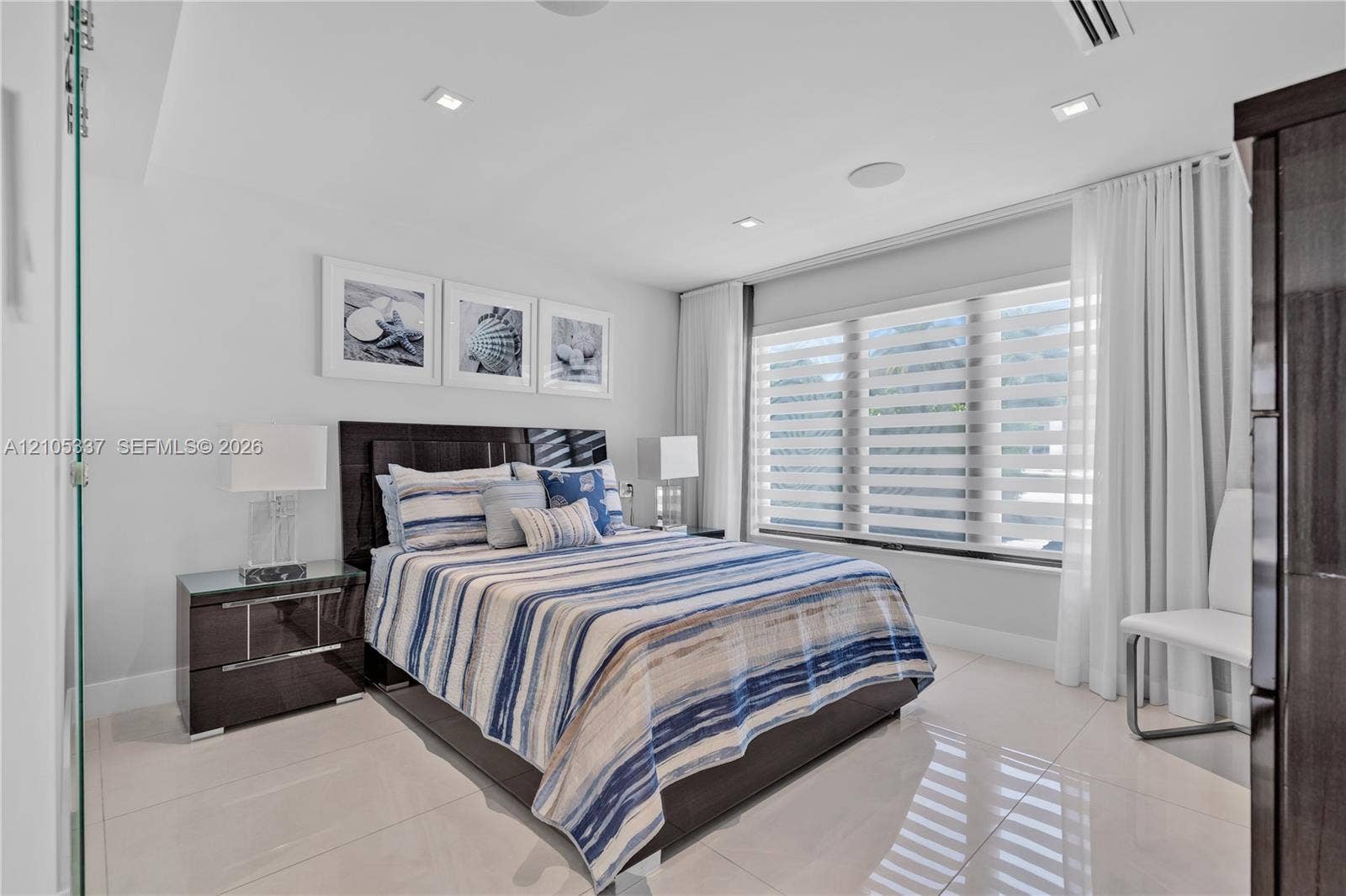 3322 NE 166th Street, North Miami Beach, FL 33160 Neutral-toned porcelain tile flooring, recessed ceiling lighting, and large windows with horizontal banded shades