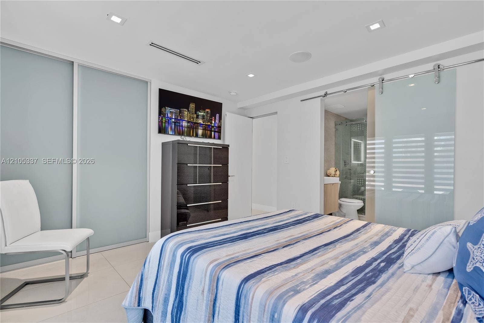 3322 NE 166th Street, North Miami Beach, FL 33160 Frosted glass sliding closet doors, ceiling recessed lighting, polished tile flooring, and a frosted glass sliding barn door with stainless steel hardware