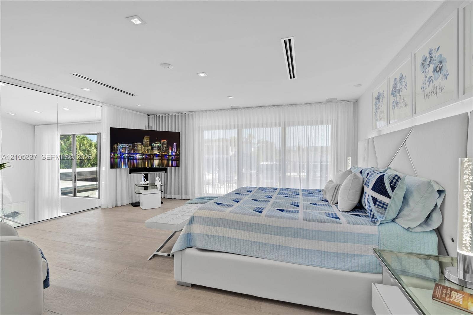 3322 NE 166th Street, North Miami Beach, FL 33160 Interior space featuring wood-finish flooring, floor-to-ceiling glass wall, recessed lighting, and wall-to-wall drapery