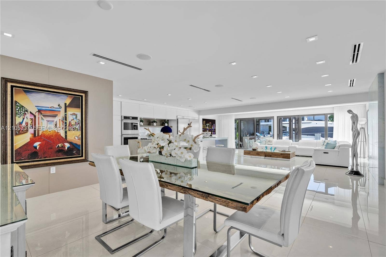 3322 NE 166th Street, North Miami Beach, FL 33160 Open-concept living space featuring high-gloss tile flooring, recessed lighting, linear HVAC diffusers, and retractable glass doors