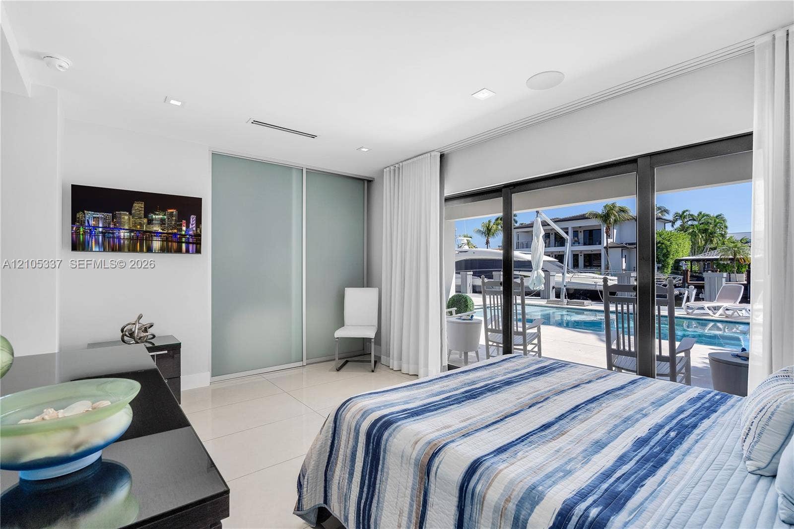 3322 NE 166th Street, North Miami Beach, FL 33160 Large-format ceramic floor tiling, floor-to-ceiling glass sliding doors, recessed lighting, and built-in sliding panel closet doors