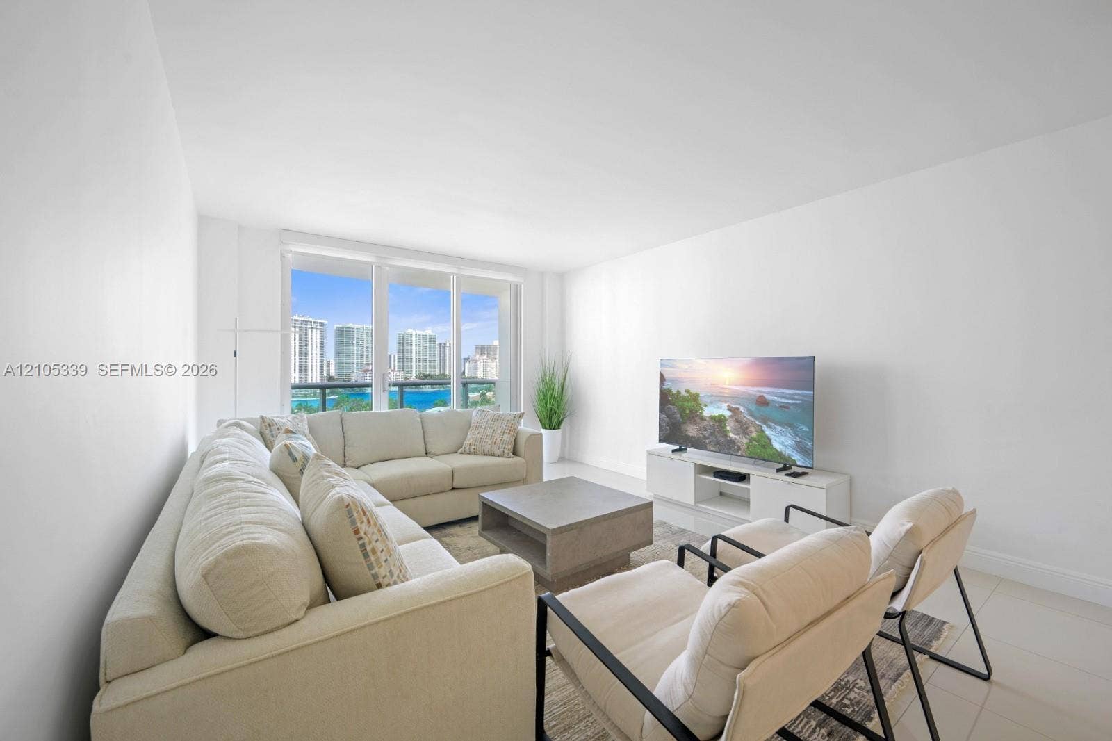 Spacious room with floor-to-ceiling windows, white walls, and light-colored tile flooring
