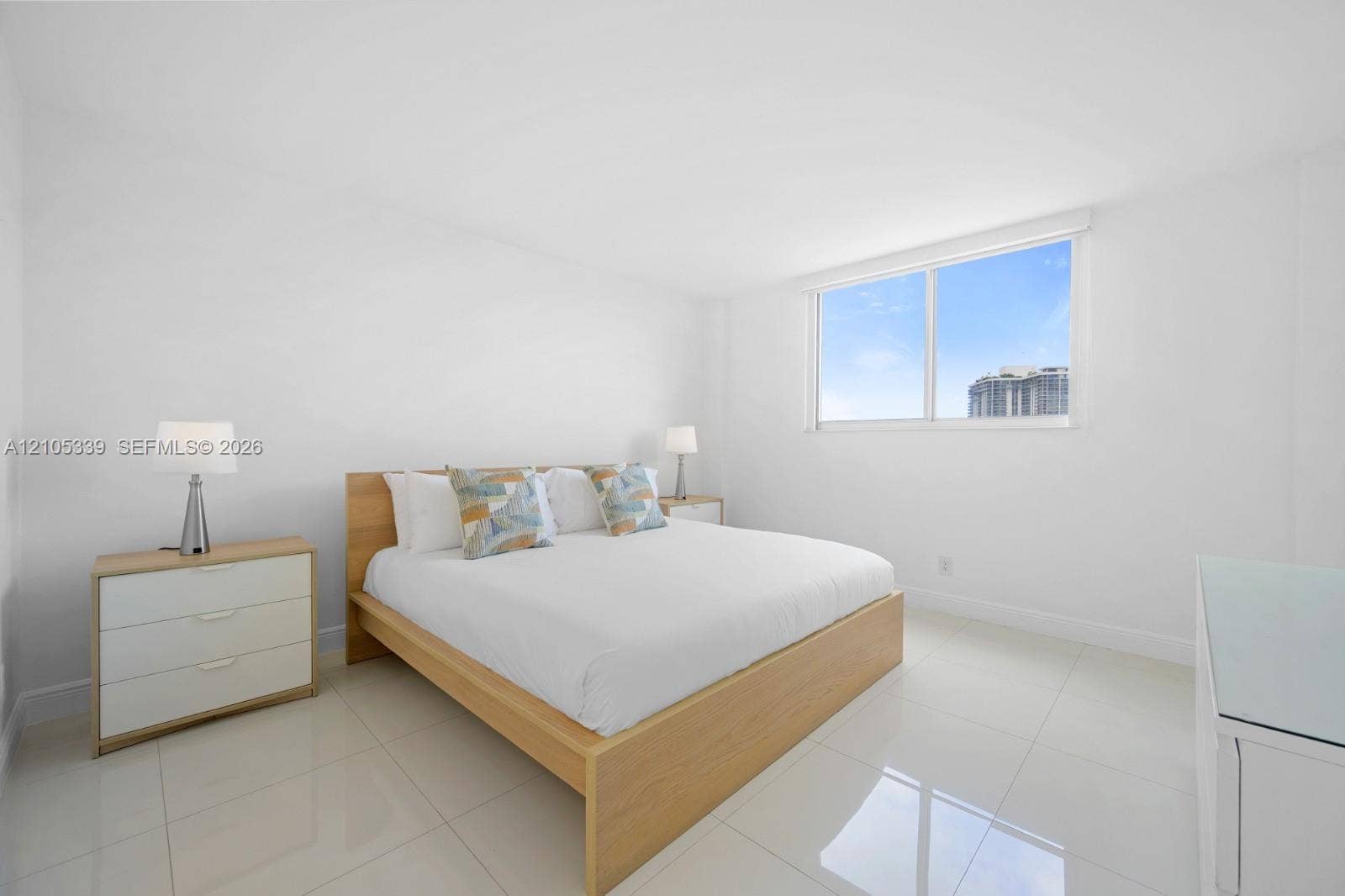 White walls, white tile flooring, and large window