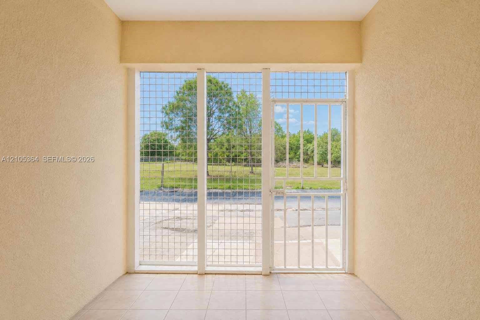 Full-height window system with security grilles, tile flooring, and textured wall finishes