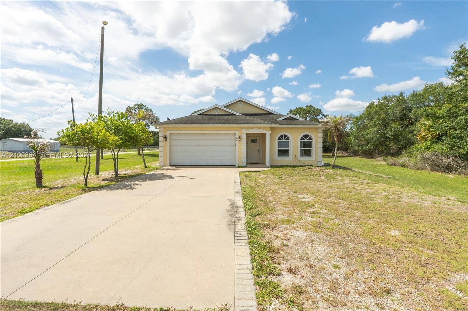 Single-story residence featuring a front entry, arched windows, and an attached two-car garage
