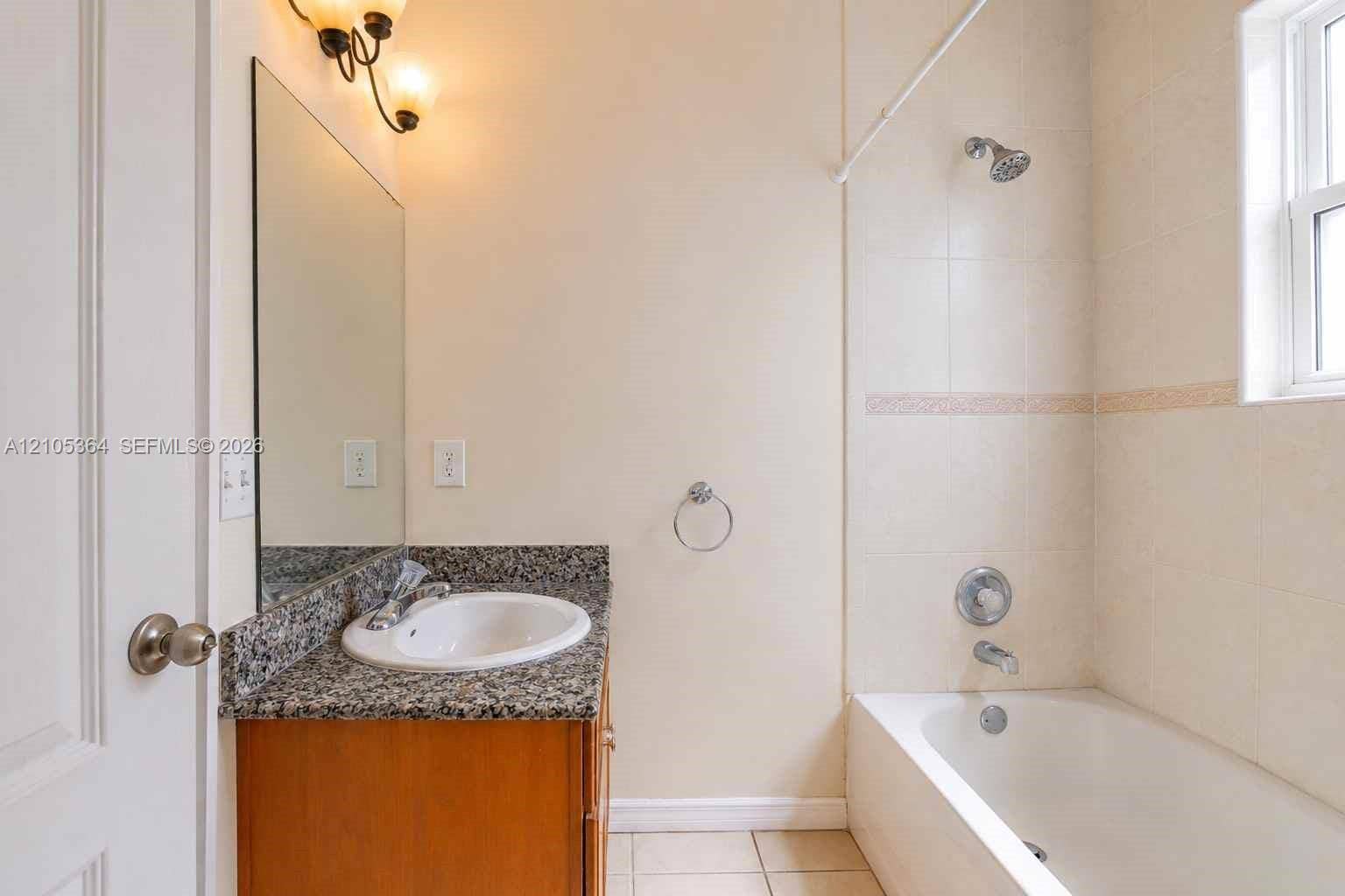 Warm wood-finish vanity with a granite-style countertop