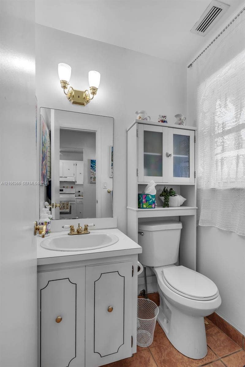 White vanity with integrated sink and brass-finish faucet