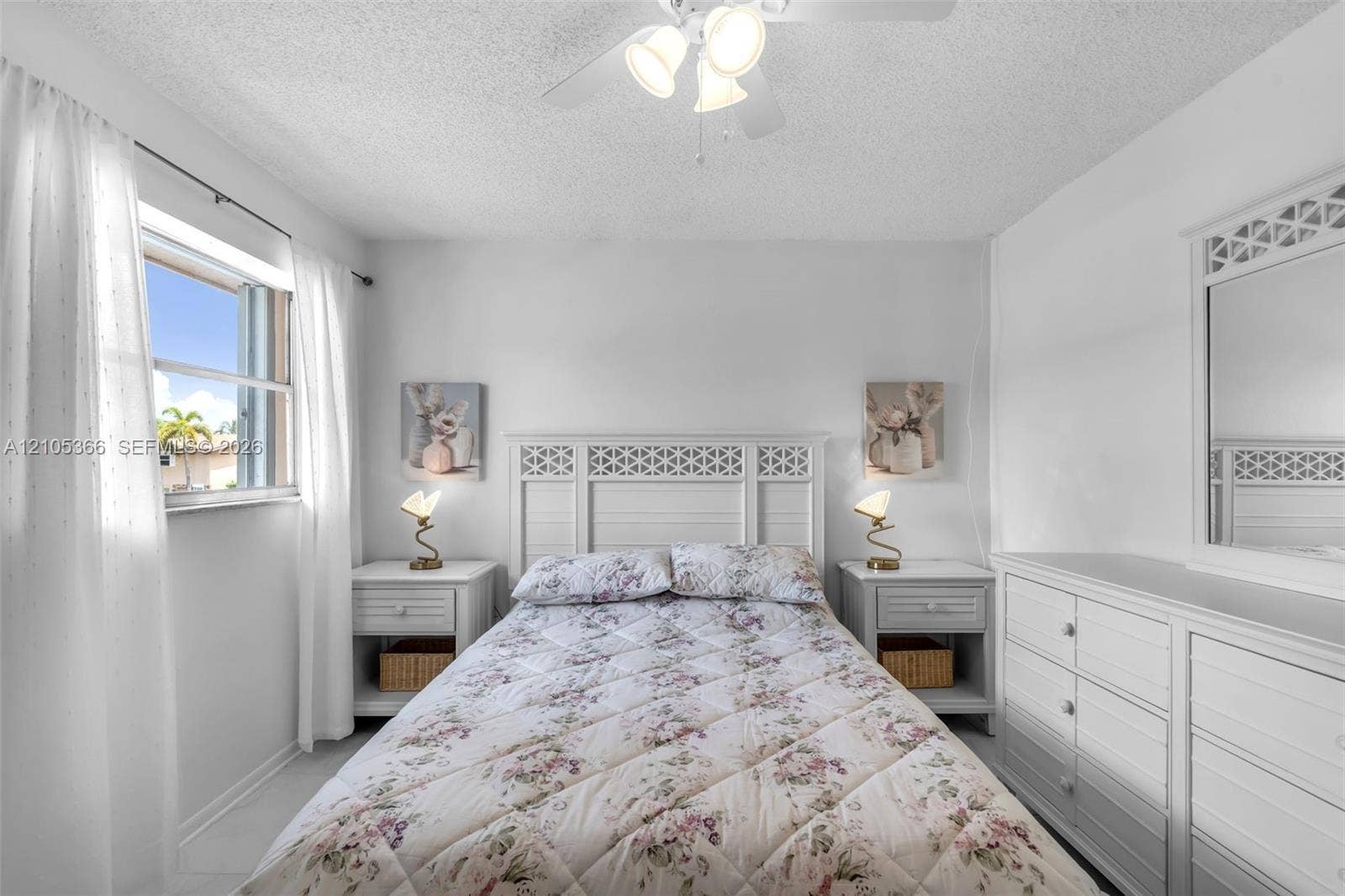 White walls, window with natural light, and a ceiling fan with integrated lighting