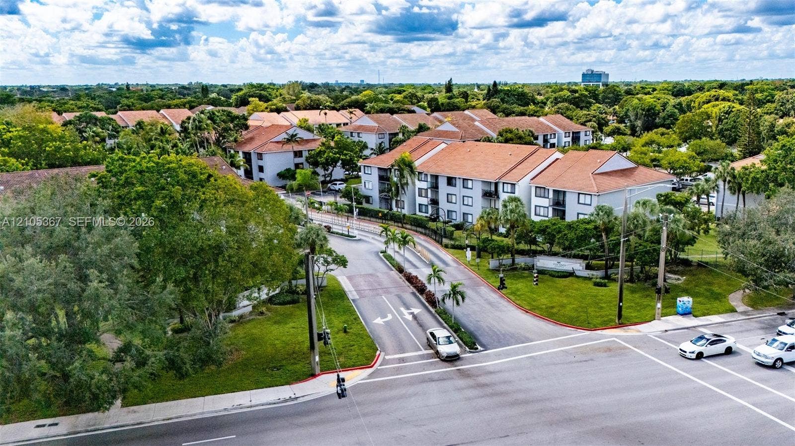 9066 W Atlantic Boulevard, #412, Coral Springs, FL 33071 Aerial view of multi-story residential buildings featuring tile roofs, light-toned exterior facades, and extensive landscaping with mature trees and maintained lawns