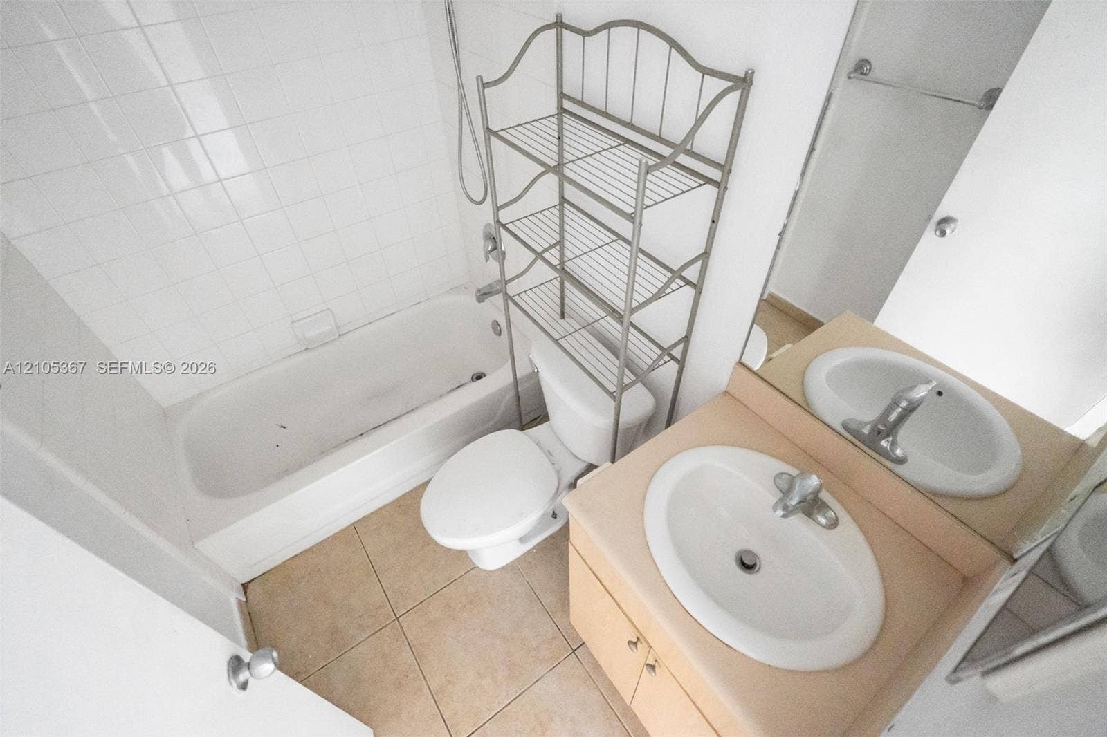 9066 W Atlantic Boulevard, #412, Coral Springs, FL 33071 Bathroom featuring a shower and bathtub combination with white wall tile, a vanity with an integrated oval sink, and ceramic floor tile