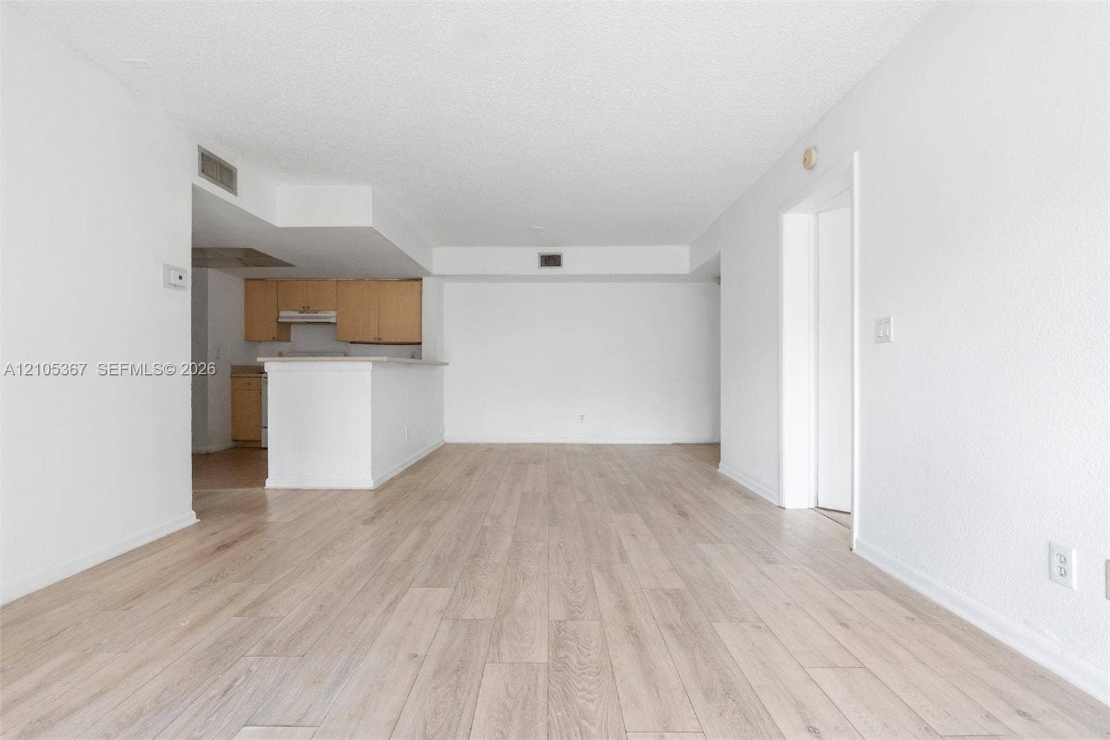 9066 W Atlantic Boulevard, #412, Coral Springs, FL 33071 Open-concept interior featuring wood-finish flooring, white walls, and a breakfast bar