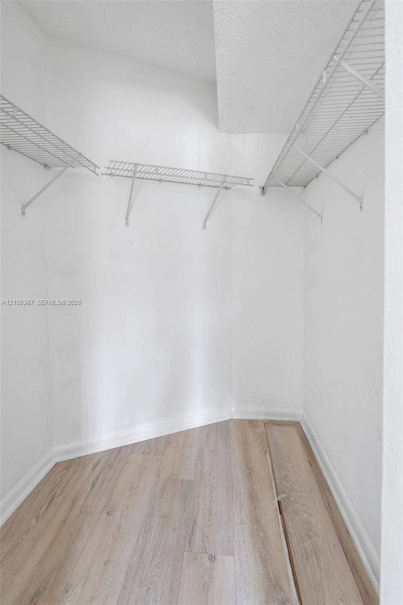 9066 W Atlantic Boulevard, #412, Coral Springs, FL 33071 Walk-in storage space featuring wood-finish flooring and white wire shelving