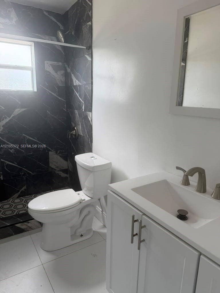 White vanity with brushed nickel hardware, integrated sink, and brushed nickel faucet