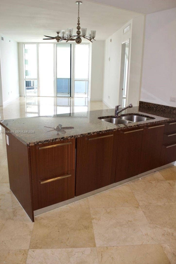 16001 Collins Avenue, #2803, Sunny Isles Beach, Sunny Isles Beach, FL 33160 Kitchen island with stone countertop, stainless steel double basin sink, and wood-finish cabinetry