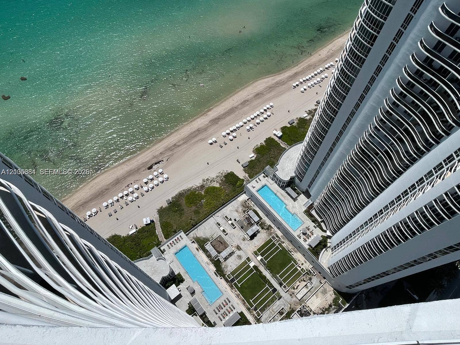 16001 Collins Avenue, #2803, Sunny Isles Beach, Sunny Isles Beach, FL 33160 Oceanfront property featuring two outdoor swimming pools, a sandy beach, and manicured green spaces