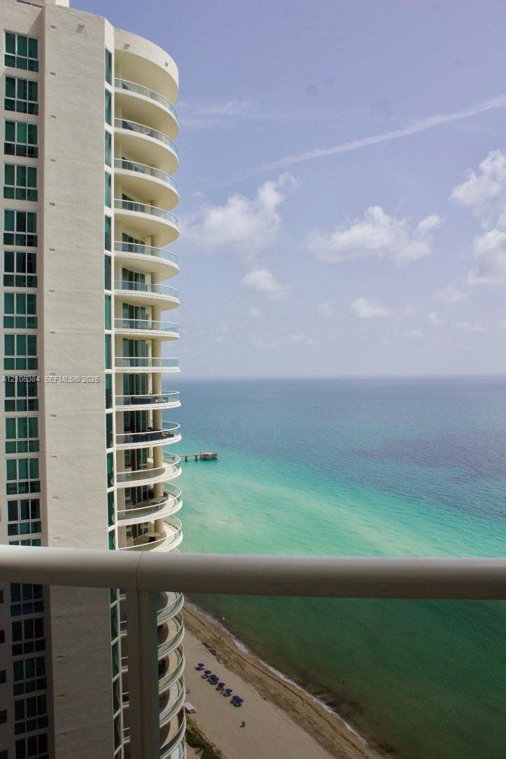 16001 Collins Avenue, #2803, Sunny Isles Beach, Sunny Isles Beach, FL 33160 Building exterior featuring a light-colored facade, numerous large windows, and curved balconies with glass railings