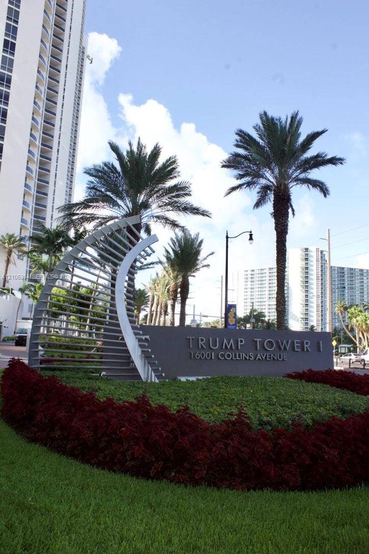 16001 Collins Avenue, #2803, Sunny Isles Beach, Sunny Isles Beach, FL 33160 Landscaped entrance featuring a prominent monument sign, manicured shrubs, and mature palm trees
