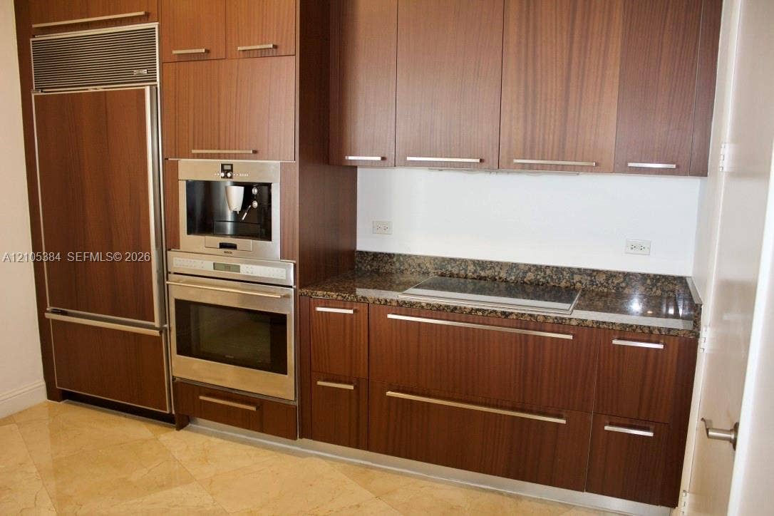 16001 Collins Avenue, #2803, Sunny Isles Beach, Sunny Isles Beach, FL 33160 Integrated panel-front refrigerator, built-in coffee maker, stainless steel oven, cooktop, and stone countertops