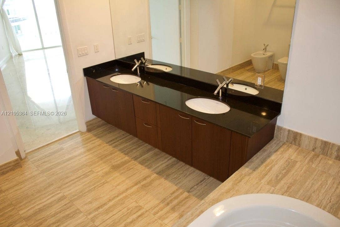 16001 Collins Avenue, #2803, Sunny Isles Beach, Sunny Isles Beach, FL 33160 Dual sink vanity with dark wood-finish cabinetry and a black countertop