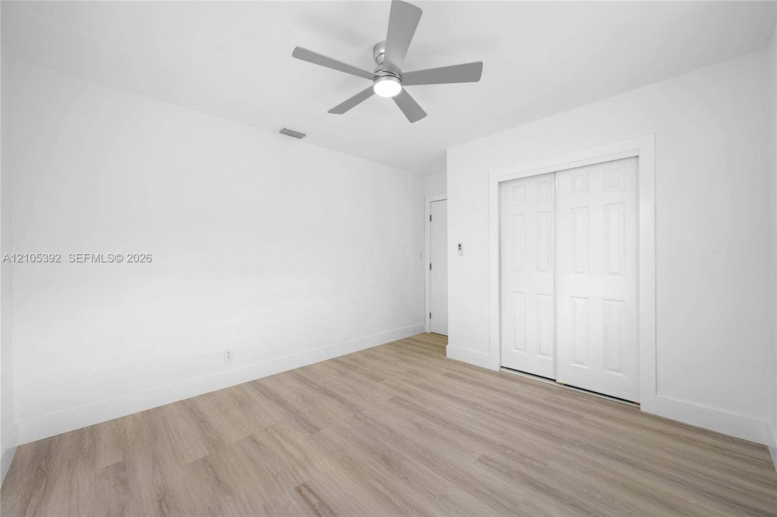 3197 Cleveland Street, Hollywood, FL 33021 Light-toned wood-finish flooring, white walls, and a contemporary ceiling fan with integrated lighting