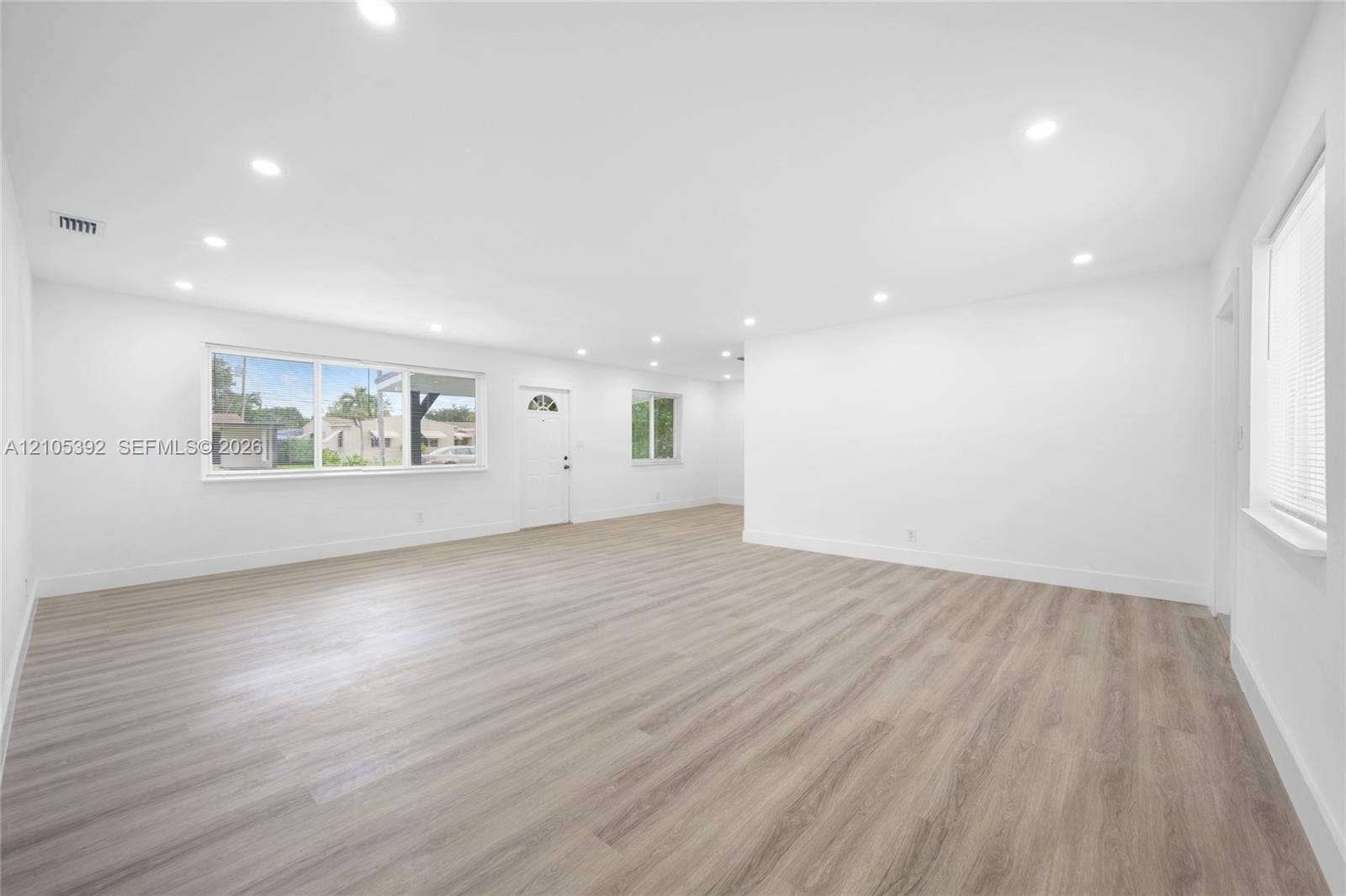 3197 Cleveland Street, Hollywood, FL 33021 Spacious room with wood-finish flooring, white walls, multiple windows, and recessed lighting