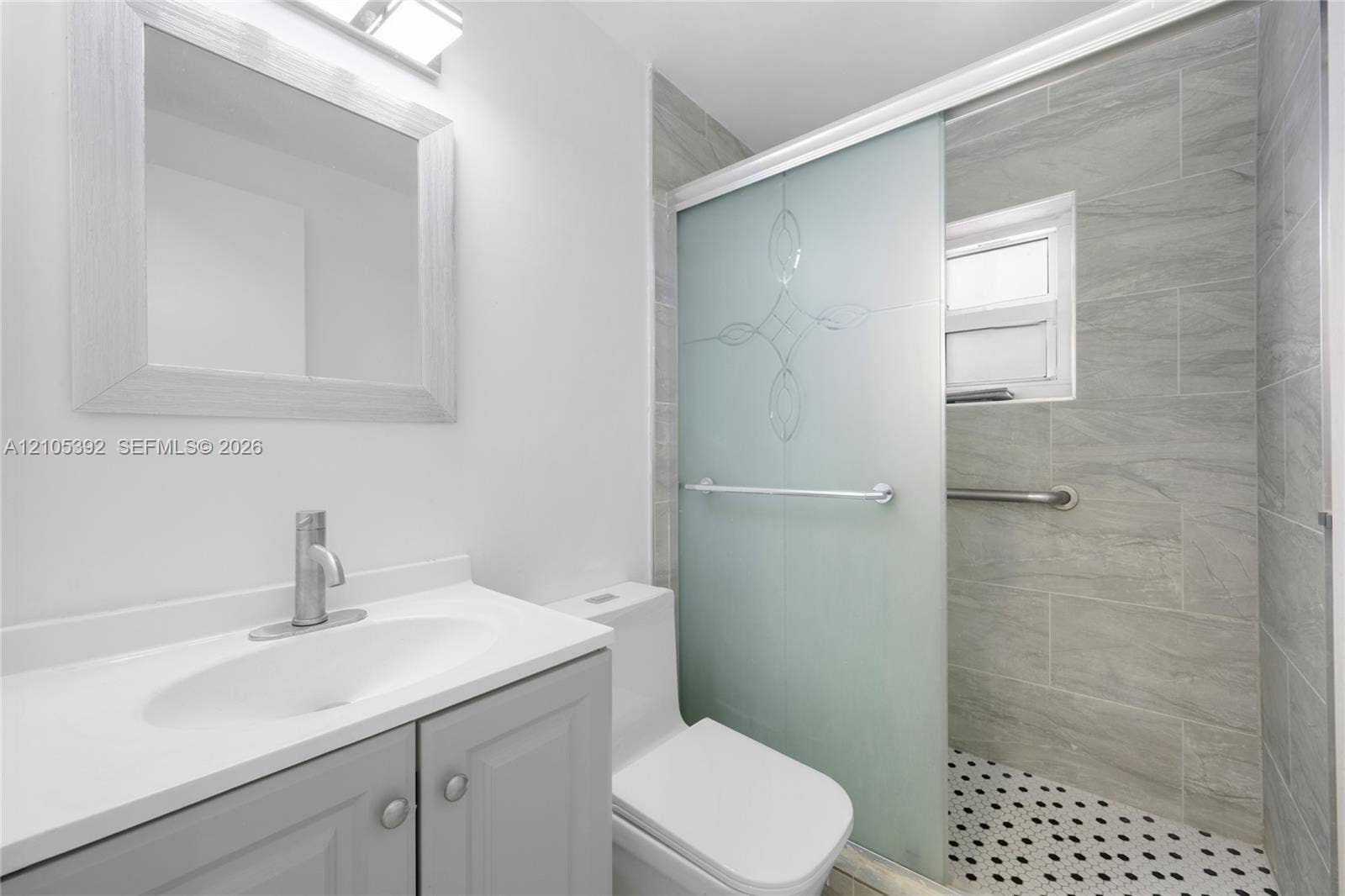 3197 Cleveland Street, Hollywood, FL 33021 Modern vanity with undermount sink, a framed mirror, and a frosted glass shower door with patterned detail
