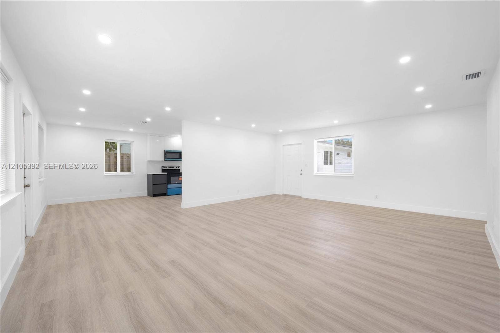 3197 Cleveland Street, Hollywood, FL 33021 Spacious open-concept interior featuring light wood-finish flooring, recessed lighting, and crisp white walls