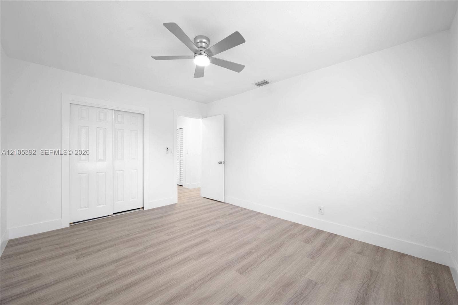 3197 Cleveland Street, Hollywood, FL 33021 Light-toned wood-finish flooring, white walls, and a ceiling fan with integrated lighting