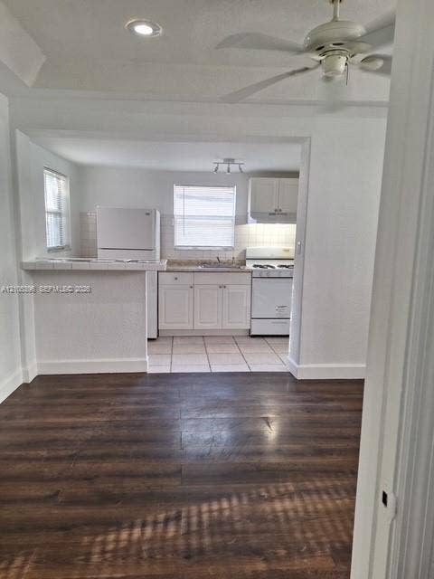 Wood-finish flooring, recessed lighting, and a ceiling fan