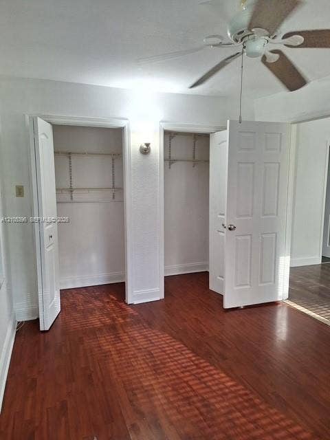 Recessed closets with wire shelving, wood-finish flooring, ceiling fan with light fixture