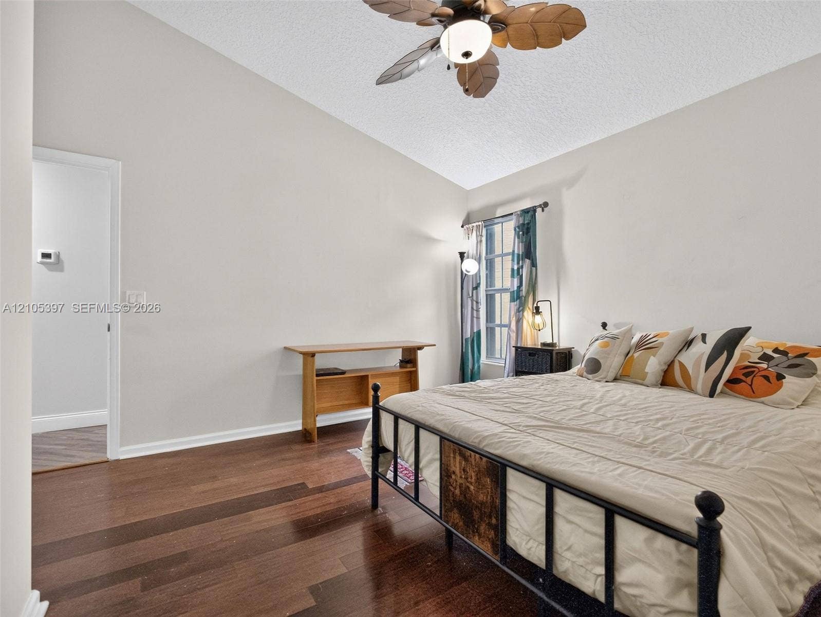 Vaulted ceiling, laminate flooring, and a ceiling fan with integrated lighting