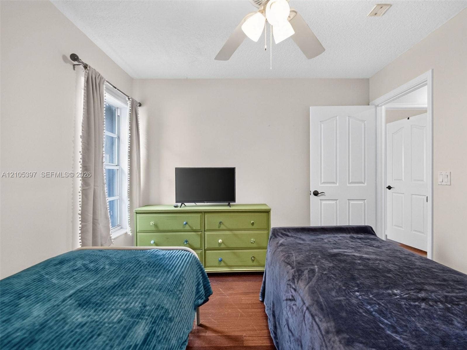 Interior space featuring laminate flooring, a multi-pane window, a ceiling-mounted light fixture with fan.