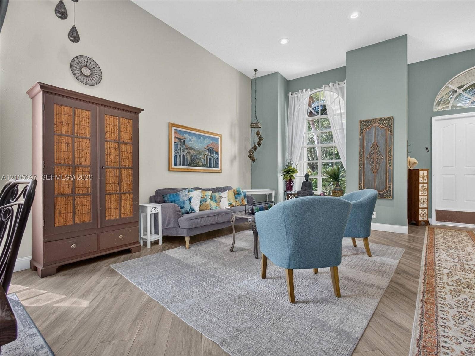 Vaulted ceilings, tall windows with arched transoms, recessed lighting, and porcelain wood-finish flooring