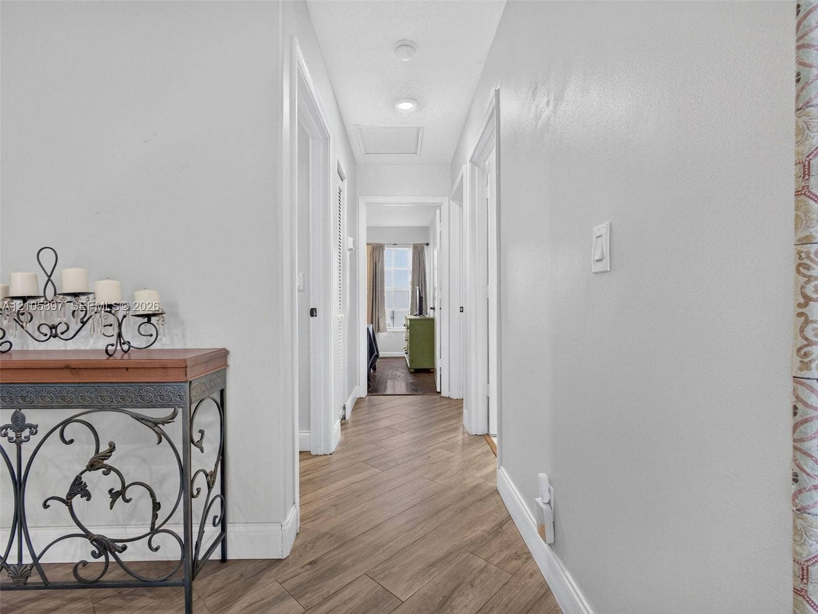 Hallway to 2nd and 3rd Bedrooms, featuring Porcelain wood-finish plank flooring, neutral paint, recessed lighting.