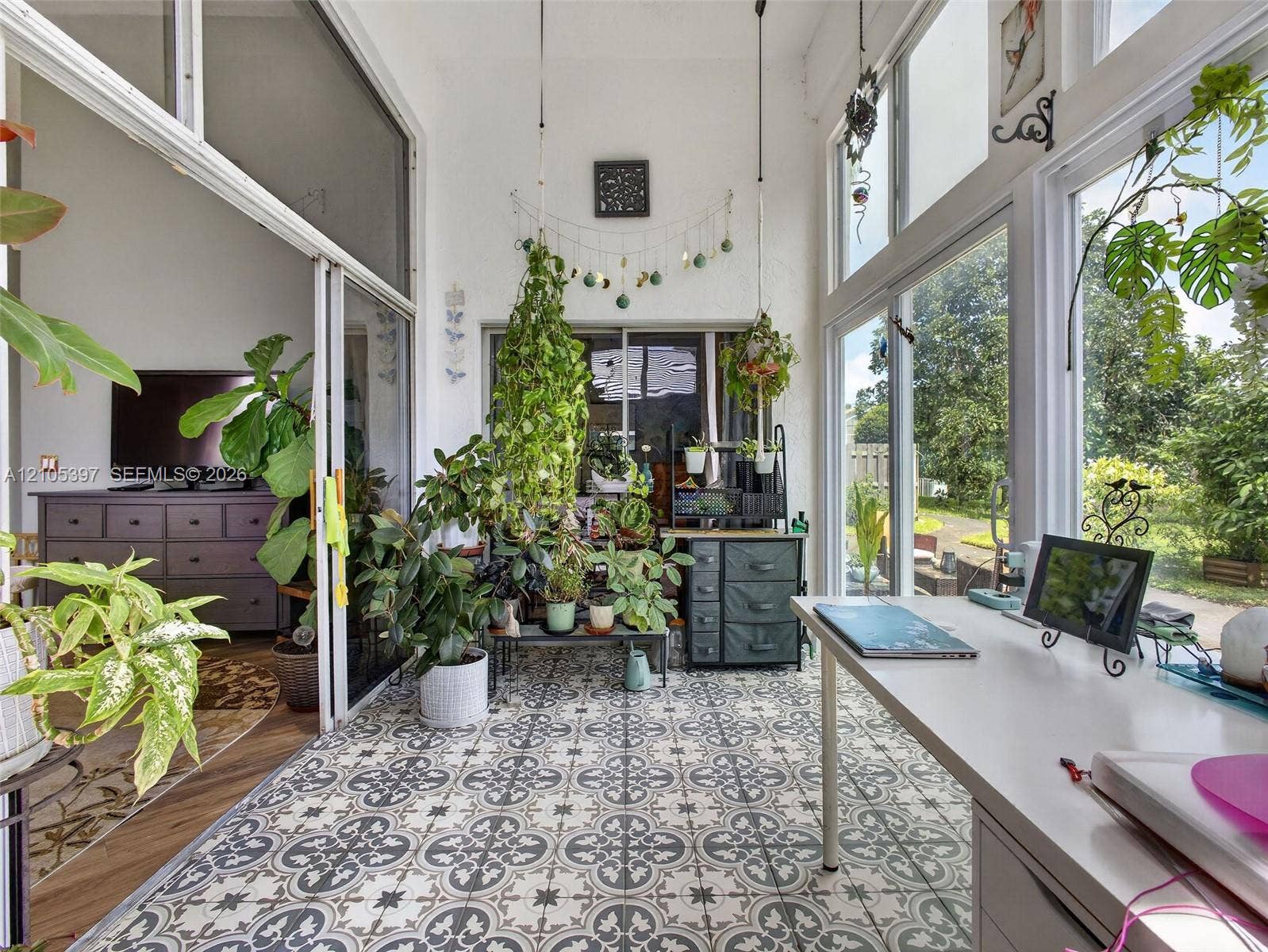 Sunroom featuring patterned ceramic floor tile, floor-to-ceiling windows, and sliding glass wall panels