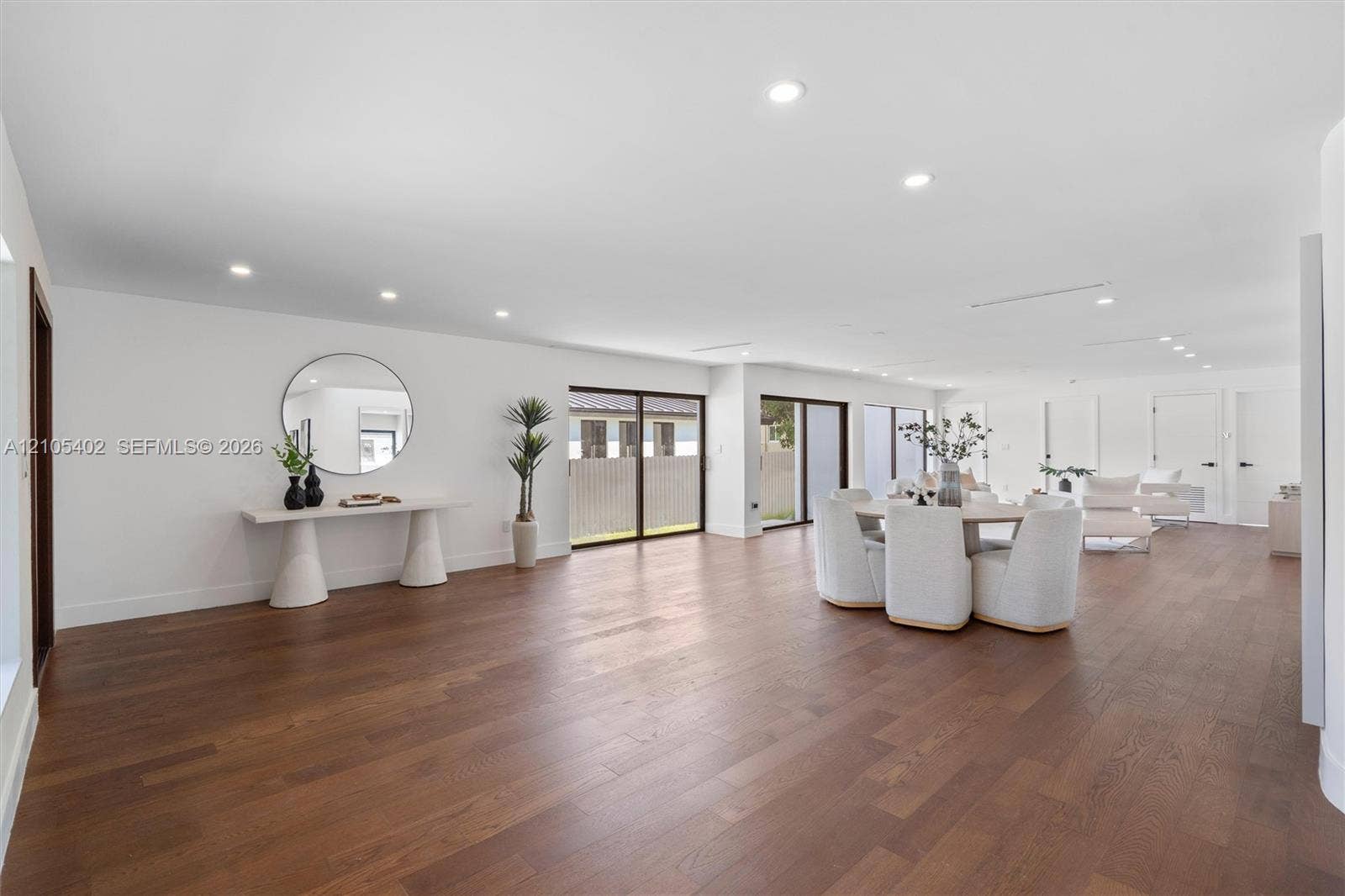 1911 SW 18th Avenue, Miami, FL 33145 Open-concept interior featuring wood-finish flooring, recessed lighting, and multiple sliding glass door sets